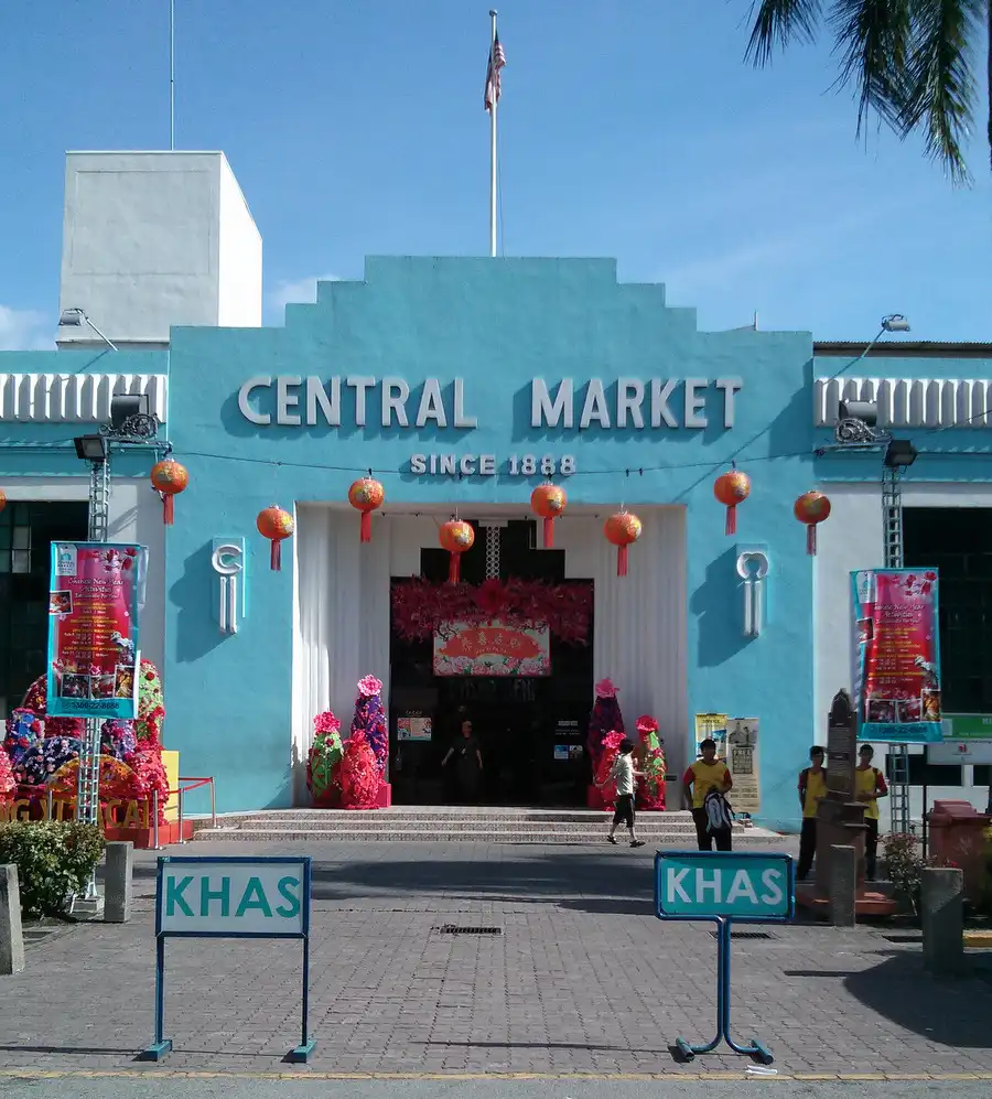Historic Central Market building in Kuala Lumpur, painted light blue, adorned with red lanterns and festive decorations at its entrance