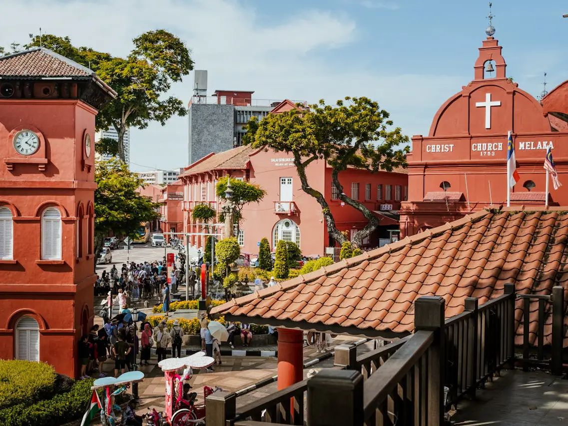 Vibrant Dutch Square Melaka, showcasing red colonial buildings like Christ Church, a clock tower, and a lively public square