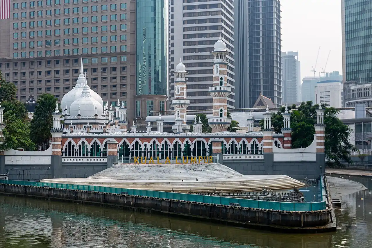 Masjid Jamek, Kuala Lumpur's beautiful mosque, stands by the river with its striking domes and minarets against modern buildings