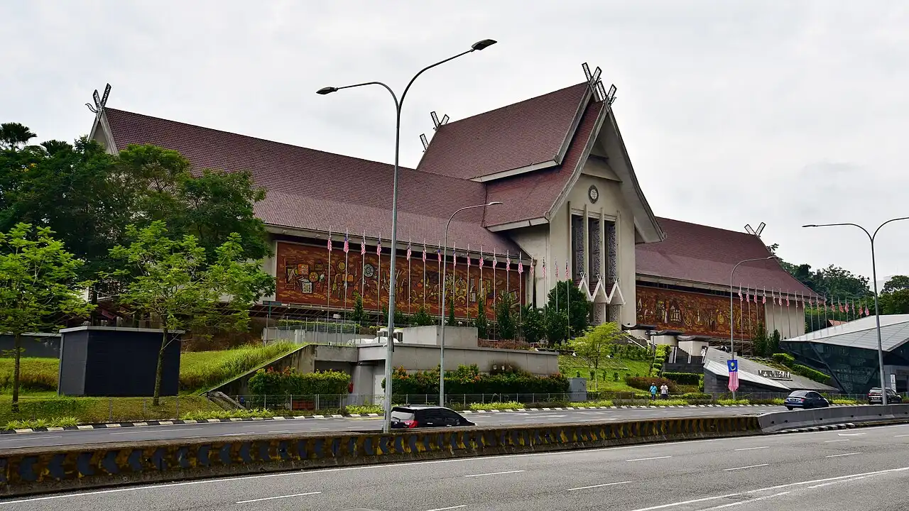 The impressive Muzium Negara, Malaysia's National Museum, featuring traditional architecture, a long mural, and Malaysian flags.