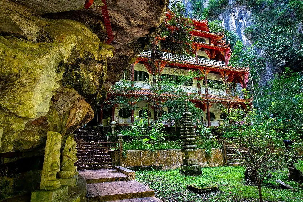 The Sam Poh Tong Temple, a stunning Buddhist cave temple in Ipoh, Malaysia, featuring ornate architecture nestled amidst lush greenery
